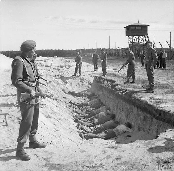 Zorla çalıştırılmaktan yorulan Alman SS muhafızları, İngiliz muhafızlar tarafından daha önce Almanların cesetleri gömmek için kazdıkları toplu mezarlarda yüz üstü bir şekilde yatırılıyor. (1945)