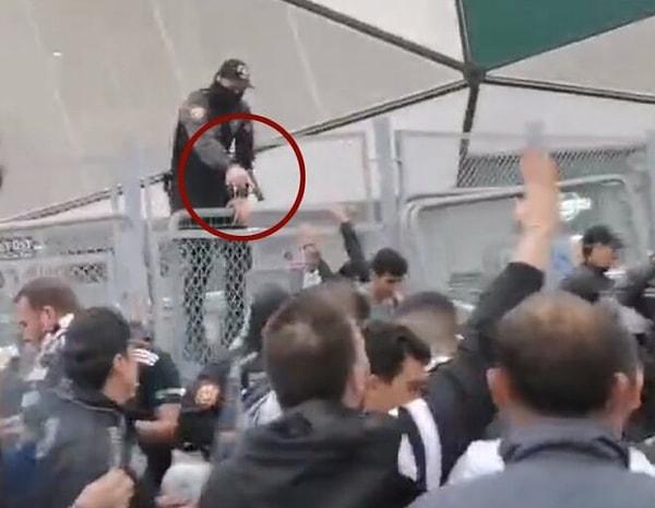 Sosyal medyada paylaşılan görüntülerde maç öncesi stadyum önünde çıkan kargaşada bir polis memurunun taraftarların üzerine doğru silah doğrulttuğu görülüyor.