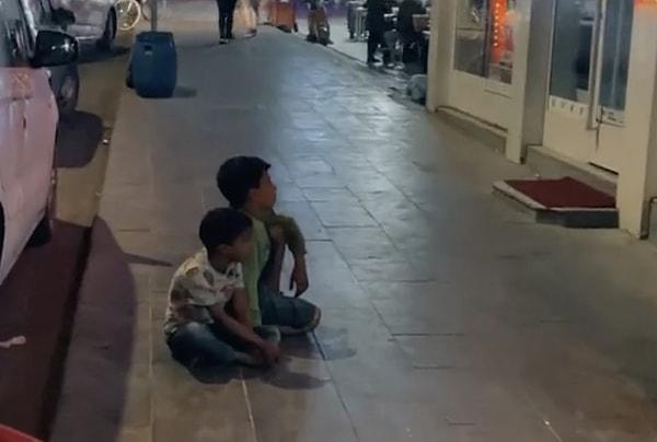 İki çocuğun kaldırıma oturup, bir mağazanın televizyonundaki çizgi filmi izlediği görüntüler sosyal medyada gündem oldu.