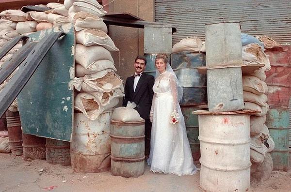 8. Lübnan'daki kurtuluş savaşı zamanı yeni evlenen bir çiftin, düğün günlerinde evlerinin yakınında poz verirken çekilmiş bir fotoğrafı. (1989)