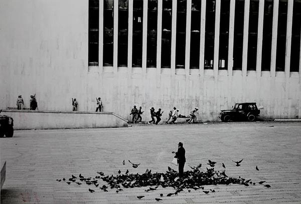 3. Solcu M-19 gerilla gurubu Adalet Sarayını kuşatırken güvercinleri besleyen bir adam. (1985)