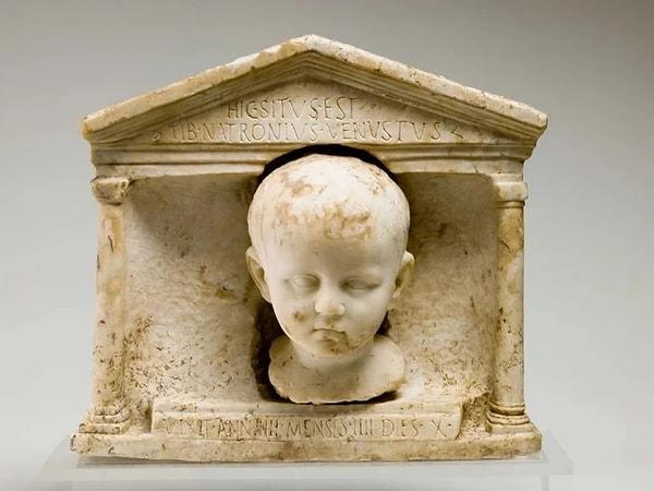 2. Küçük bir çocuğun kafasının resmedildiği Roma mezar taşı. Taşın üzerinde şöyle yazıyor: “Burada Tiberius Natronius Venustus yatıyor. 4 yıl 4 ay 10 gün yaşadı”.