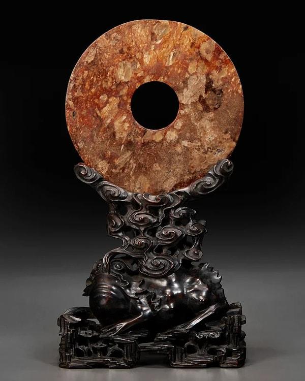 8. Çin'in Liangzhu kültürüne ait M.Ö 3. Yüzyıldan kalma Russet yeşim taşından yapılmış modern ayaklı Neolitik disk.