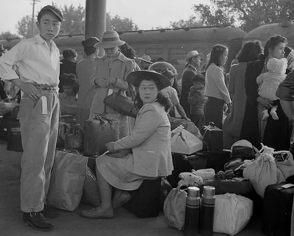 7. Bagajlarıyla birlikte Woodland, Kaliforniya'daki bir tren istasyonunda bekleyen aileler. Pearl Harbor saldırısının ardından 125.000'den fazla Japon kökenli Amerikan vatandaşı zorla tahliye edildi ve ABD'nin batısındaki "Nakil Merkezlerinde" hapsedildi.  (20 Mayıs 1942)