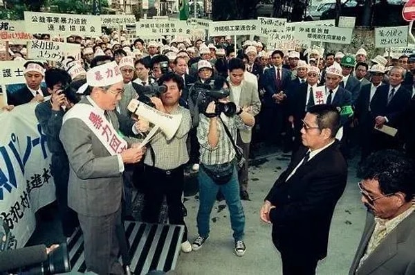 10. Yakuza karşıtı protestocuların lideri, 6. Okinawa Yakuza Savaşı sırasında Kyokuryu-kai patronunun evinin önünde grubu dağıtma konuşması yaparken çekilmiş bir fotoğraf. (1990)