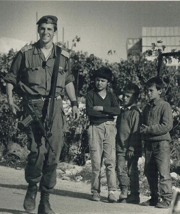 5. Filistinli çocukların yanından geçen bir İsrail askeri. (1989)