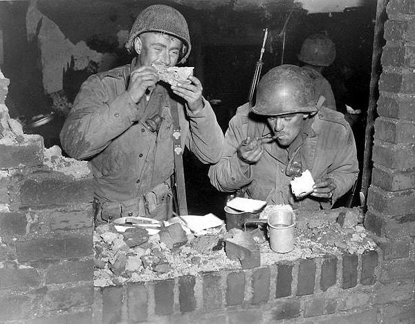 15. 23 Kasım 1944 yılında şükran günü akşamında yemek yiyen iki Amerikan askeri.