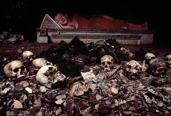 1. Kamboçya soykırımının kurbanlarıyla çevrili bir tapınağın altındaki mağarada yatan Buda heykeli. (1980)