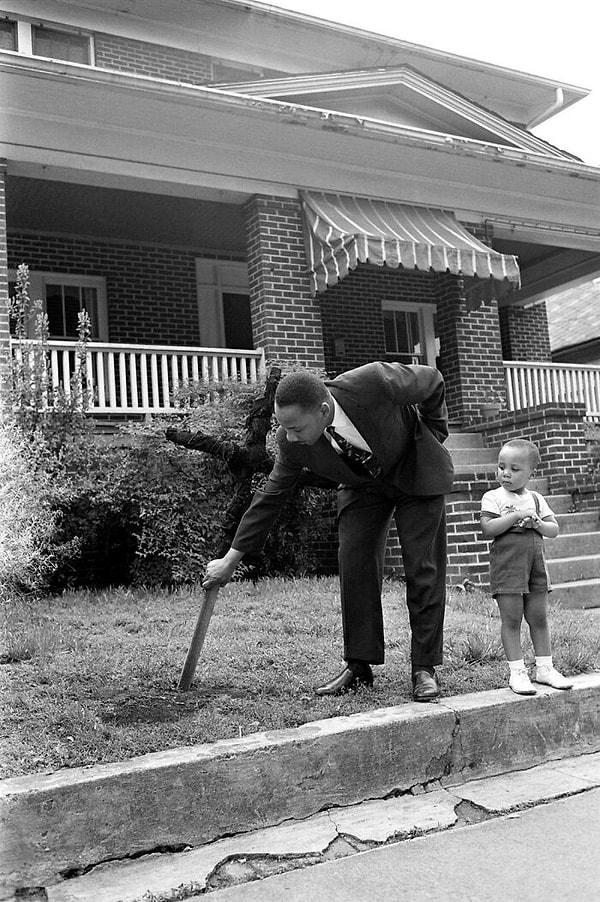10. Martin Luther King Jr. oğluyla birlikte, Atlanta'daki evinin ön bahçesinden yanmış bir haç çıkarıyor