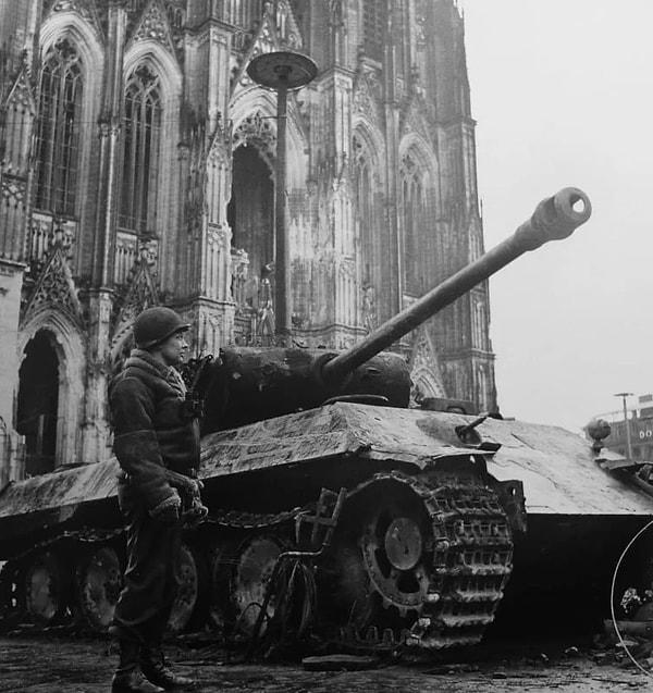 13. Bir Amerikan askeri, Mart 1945'te Köln Katedrali'nin önünde, harap olmuş bir Alman Panter tankının yanında poz veriyor.