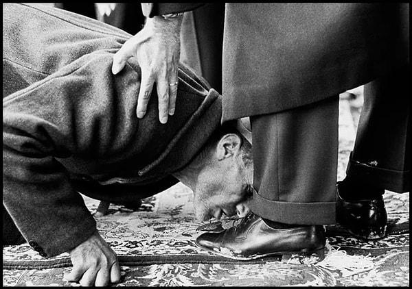 3. Bir köylü, İran Şahı Muhammed Rıza Pehlevi törenle arazi tapularını dağıtırken Pehlevi'nin ayağını öpüyor. (1962)