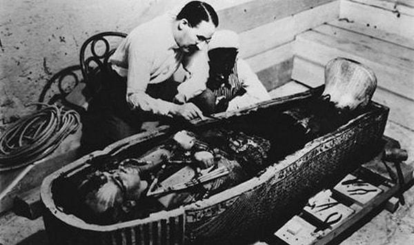10. 1922'de keşfedilen Tutankhamun'un altın lahitini inceleyen Howard Carter.