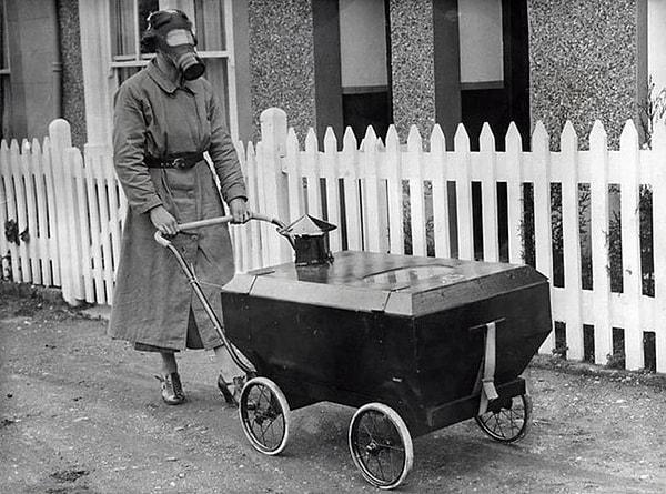 13. İkinci Dünya Savaşı'nda gaz koruyu maske ve bebek arabası ile yürüyüşe çıkmış bir kadın.
