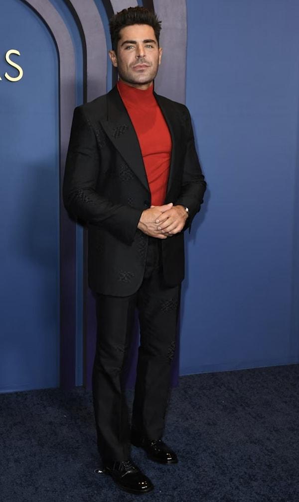 Zac Efron takımının içine kırmızı boğazlı kazak giyerek katılmış...