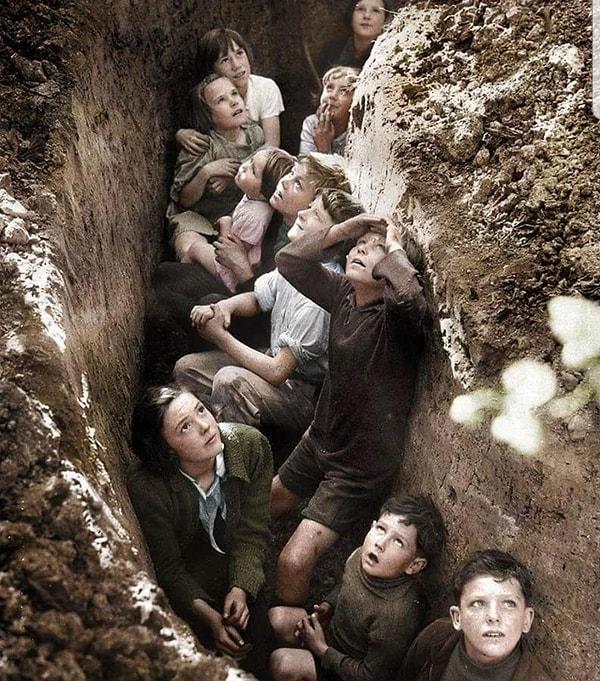 13. İkinci dünya savaşında bombardıman görevinde olan Alman savaş uçaklarından saklanmaya çalışan İngiliz çocuklar. (3 Eylül 1940)