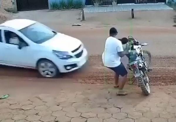 Bir baba çocuğunu motosikletine bindirdiği sırada, bir araba hızla çocuğa yaklaştı.