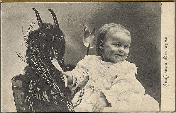 A photograph of a baby taken with the character named Krampus.