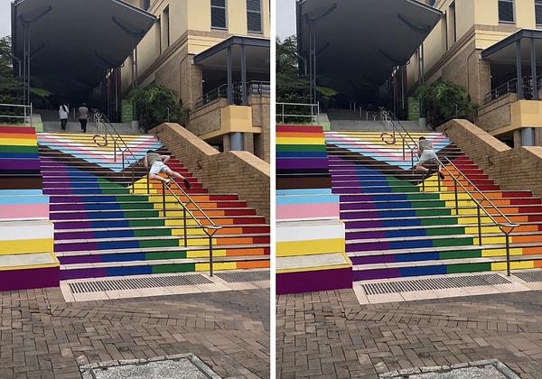 Bir genç LGBT bayraklarının renklerine boyanmış merdivenleri kullanmamak için tırabzanları kullanarak yukarı çıktı.