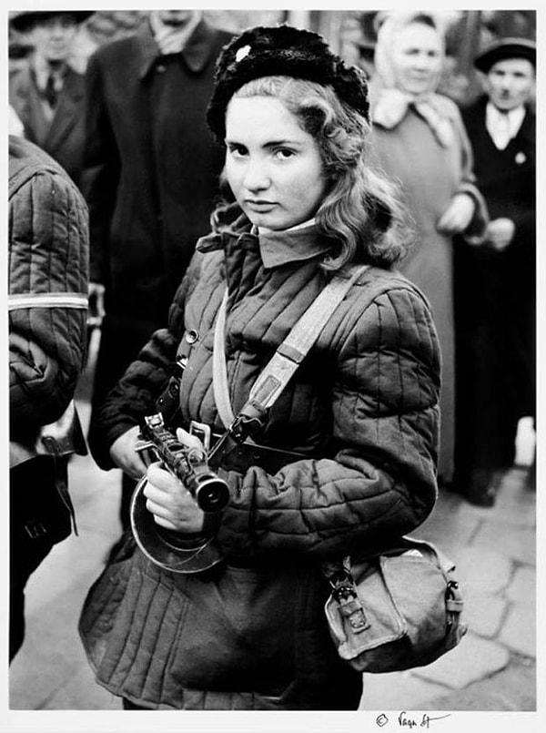 13. 1956'daki Macar Devrimi sırasında kameralara poz veren 15 yaşındaki savaşçı ve hemşire Erika Kornélia Szeles. Fotoğraf, Danimarkalı fotoğrafçı Vagn Hansen tarafından çekildi. Bu fotoğraf, birçok Avrupa dergisinin kapaklarını süsledi. Erika, bir hafta sonra, 7 Kasım 1956'da çatışmada öldü.