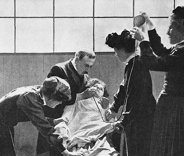 3. Bir doktor, 1912'de Londra, ingiltere'de hemşireler onu tutarken, bir kadın oy hakkı mahkumunu burnundan zorla besliyor.