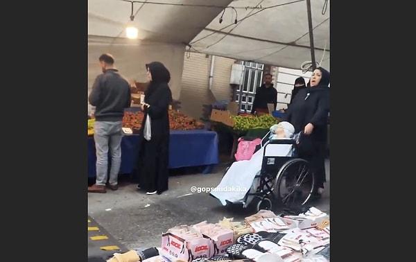 Bir kadın, ağzında oksijen maskesi olan çocuğuyla bir pazar yerinde insanlardan yardım istedi.
