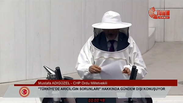 Ardından beraberinde kürsüye getirdiği arıcı kıyafetini giyen Adıgüzel, "Korkmayın arkadaşlar, bu bir arıcının resmi. Bu emeğin, alın terinin resmi, sizlere sağlıklı bal yedirmek için evlerinden, ocaklarından uzaklarda, dağ başlarında, çadırlarda ve barakalarda aylarını, yıllarını veren insanların resmi. Defalarca konuştuk, kulaklarınızın dikkatini çekemedik. Belki gözlerimizin dikkatini çekeriz diye bunu yapıyorum. Sadece arılar için değil, sizin için de konuşuyorum. Sağlıklı bal yemeğe hakkı olan herkes için çocuklar, hamile kadınlar, yurtlardaki öğrenciler, askerdeki Mehmetçikler için konuşuyorum. Sahte balla zehirlenen bütün toplum için konuşuyorum. Arılara ihtiyacı olan doğal hayat, çiçekler, meyveler için konuşuyorum, itiraz edeni de tütsülüyorum" ifadelerini kullandı.