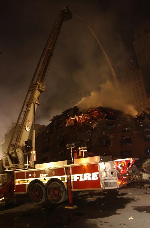 14. Dünya Ticaret Merkezi'nin enkazı arasında yanmaya devam eden yangınlarla savaşan sıfır noktasındaki itfaiyeciler. (18 Eylül 2001)