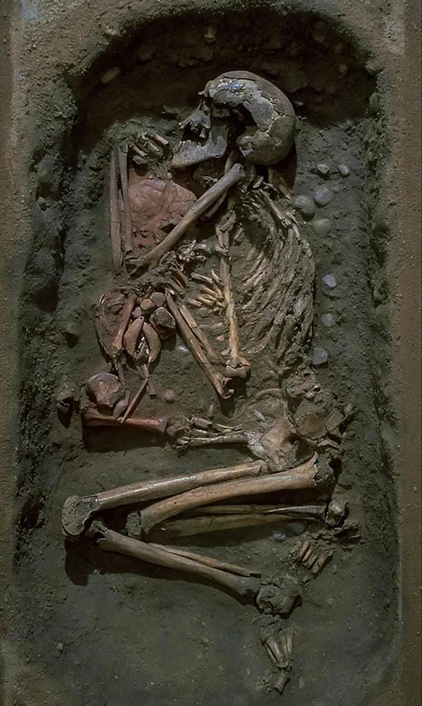 11. Yaklaşık 7000 yıl önce, İsveç'teki Skateholm'da 60'lı yaşlarında gömülen yaşlı bir adam. Hemen yanında, yaşlı adamdan daha sonra gömülmüş ve üzerine kırmızı aşı boyası serpilmiş 4-5 yaşlarında bir çocuk yatmaktadır. Çocuğun göğsünde ayı dişlerinden ve kehribar parçalarından yapılmış takılar bulunmaktadır.