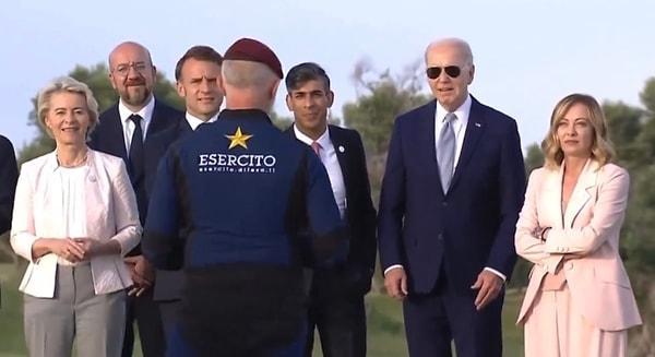 Joe Biden ilk olarak paraşütün indiği noktaya arkasını dönünce İtalya Başbakanı Georgia Meloni olaya müdahale etti ve Biden’ı kolundan tutarak çevirdi.