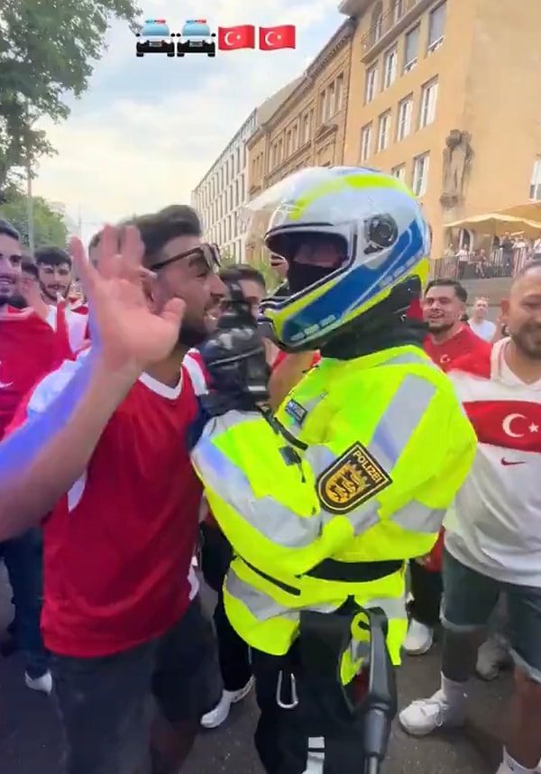 Güvenliği sağlamak için kalabalıkla birlikte duran Alman polis ile Türk vatandaşlardan biri sohbet ediyordu.