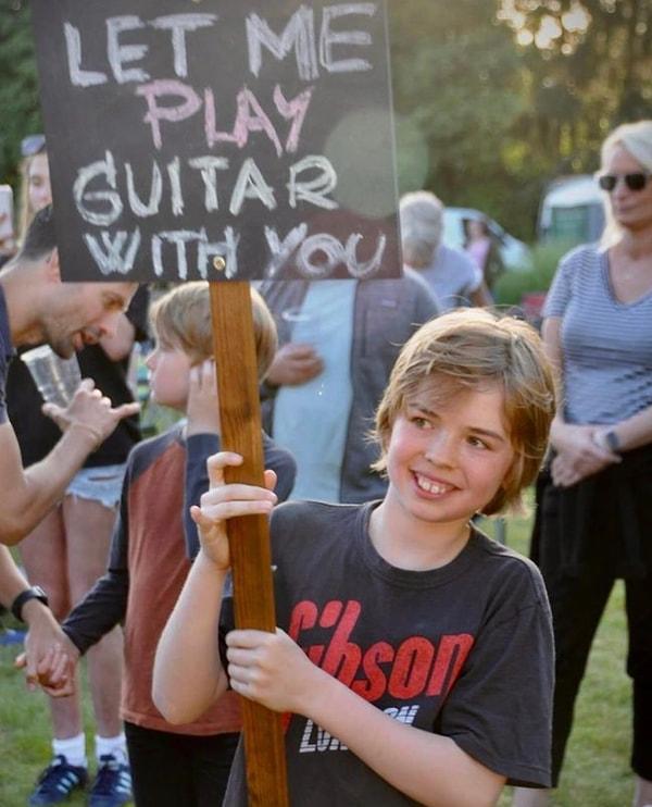 Elindeki pankartta sahnedeki grupla birlikte gitar çalmak istediğini belirten çocuğun isteği kısa sürede gerçekleştirildi.