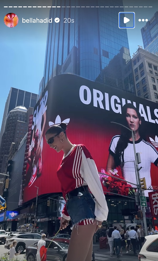 Bella Hadid reklam panosunun önünde poz verdi.