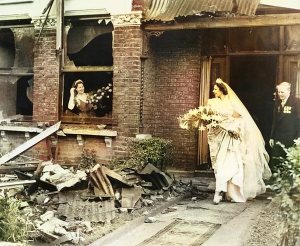 4 Kasım 1940'ta çekilen bu fotoğrafta bir kadın gelinliğiyle birlikte evlenmek üzere bombalanan evinden ayrılıyor.