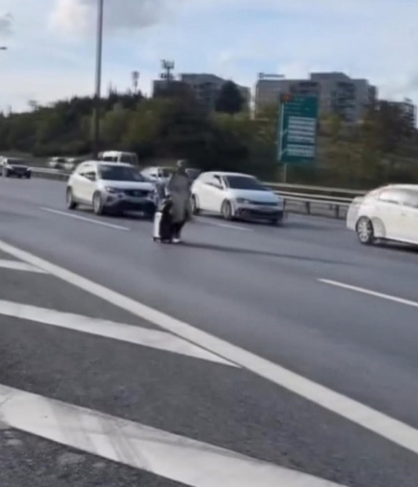 Trafiğin yoğun olduğu yolda yürüyen kadın, yanından geçen araçlara da aldırış etmedi. Kadın hem kendi hayatını hem de otoyolda seyreden sürücüleri tehlikeye attı.