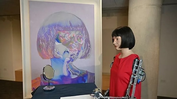 Designed in human form, Ai-Da features a chic bob haircut, a jumpsuit, robotic arms, and a realistic face.