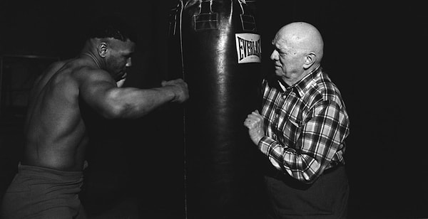 "16 yaşındayken Tyson, bir baba figürü ve akıl hocası haline gelen antrenörü Cus D’Amato ile tanıştı."