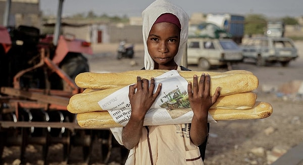 Bir çocuk, 19 Mart 2024'te Senegal'in Fass Boye kentinde, Ramazan'da orucunu açmadan önce ekmek taşıyor.