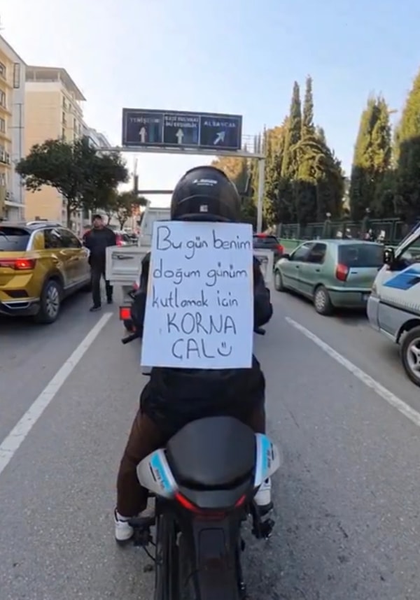 Sırtına fotoğrafta gördüğünüz yazıyı asan genç kadın, trafikte gelen tepkileri kayda alarak paylaştı.