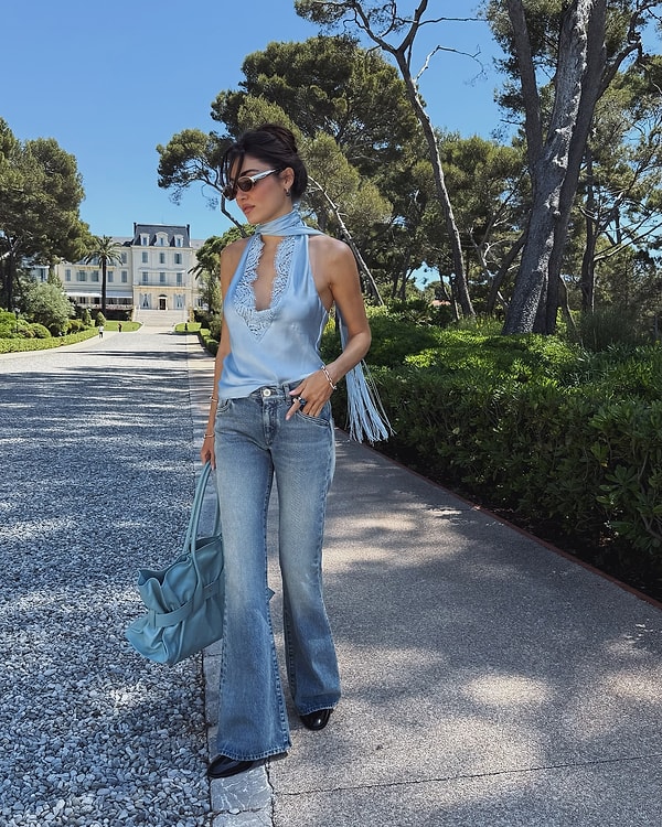 Hande Erçel, bir kez daha bizi büyüleyici tarzıyla etkiliyor. Geniş paça jean pantolonunu, saten bir bluz ile birleştirerek, zarif ve çarpıcı bir stil yaratmış.