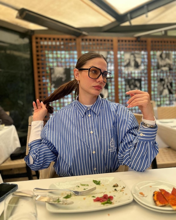 Bu sezonun trendlerinden biri olan çizgili gömlek, Demet Özdemir tarafından mükemmel bir şekilde yorumlandı. Özdemir, çizgili gömleğini içerisine giydiği beyaz body ile birleştirerek göz alıcı bir kombin oluşturmuş.