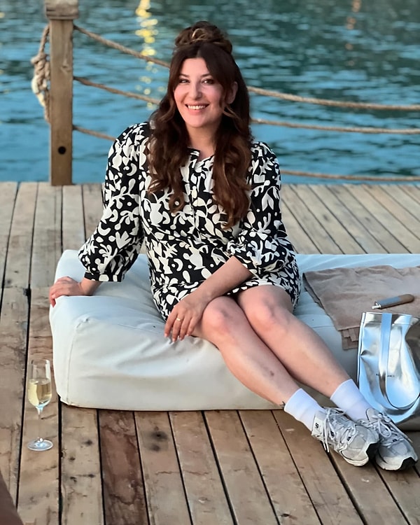 Şebnem Bozoklu, çiçek desenli elbisesini, spor ayakkabılarıyla birleştirerek, şıklığı ve rahatlığı bir arada sunmuş. Peki, siz bu stil karışımını beğendiniz mi?