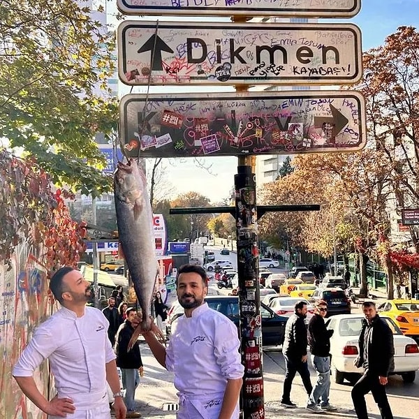 İki kişi Kızılay tabelasına kendileri asılmak yerine, astıkları balıkla poz verdi.