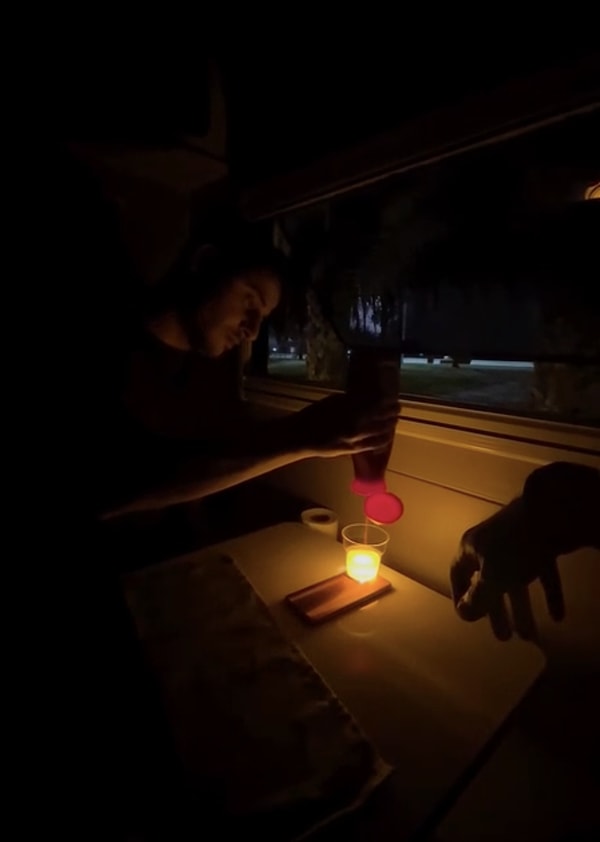 Işığın gözünü aldığını söyleyen gencin talebi üzerine arkadaşı, ışığı yumuşatmak için önce telefonun üzerine şeffaf bir plastik bardak yerleştirdi.