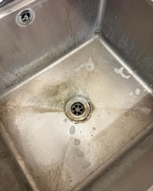 Profesyonel bir temizlik görevlisi, pas ve kireç lekeleriyle kaplanmış paslanmaz çelik bir lavaboyu basit bir yöntemle adeta ilk günkü haline getirdi.